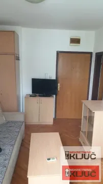 Dnevna soba sa garniturom, televizorom i drvenim nameštajem. - image 6