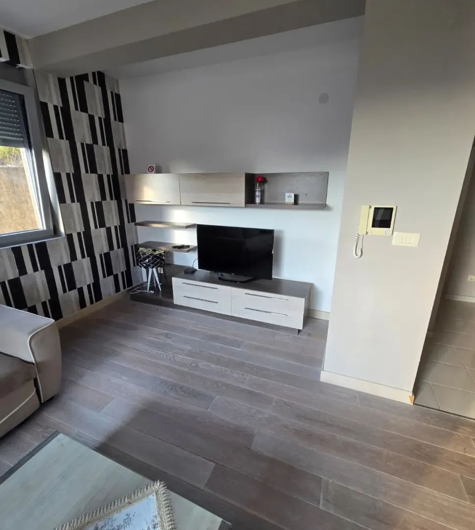 Living room with a television and wooden flooring.
