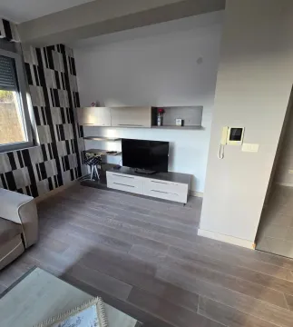Living room with a television and wooden flooring. - image 3