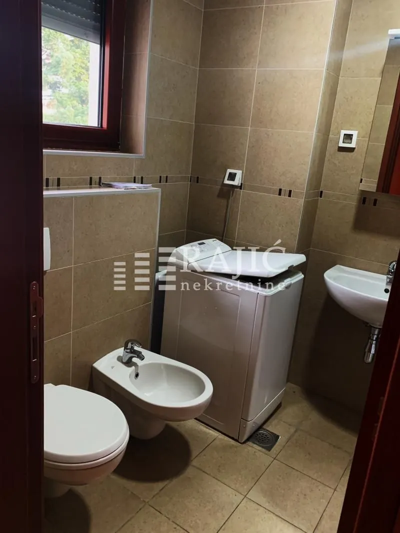 Manje kupatilo sa sanitarijama i veš mašinom.