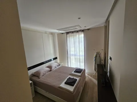 A tidy bedroom with a double bed and a window. - image 7