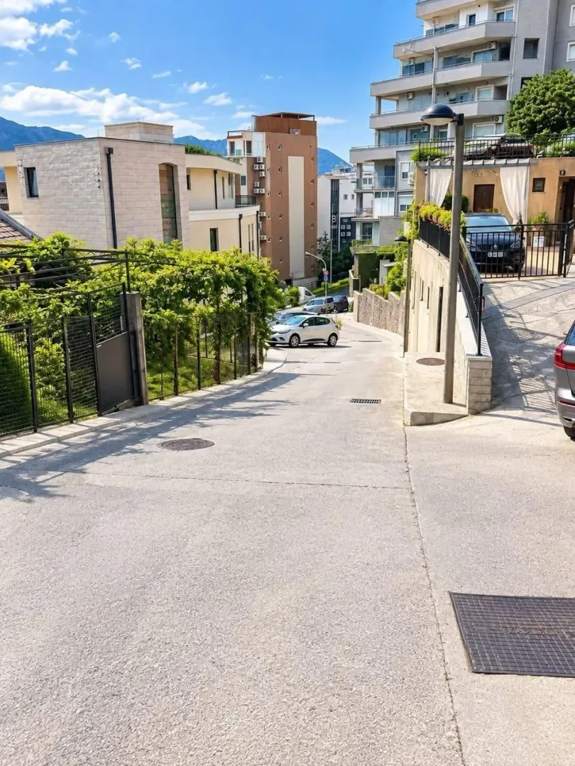 Access road to the building and surrounding streets with parked cars.