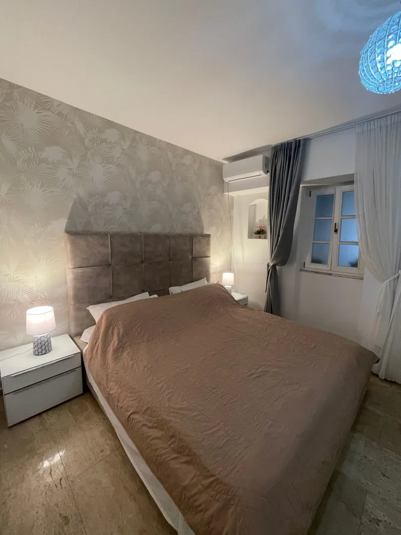 Comfortable bedroom with a double bed, nightstands, and patterned wallpaper.