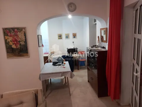 Living room with a dining table and an arched doorway leading to the kitchen. - image 4