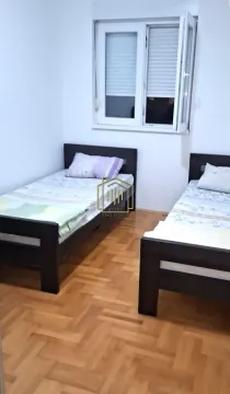 Spavaća soba sa dva kreveta i prozorom. - image 2