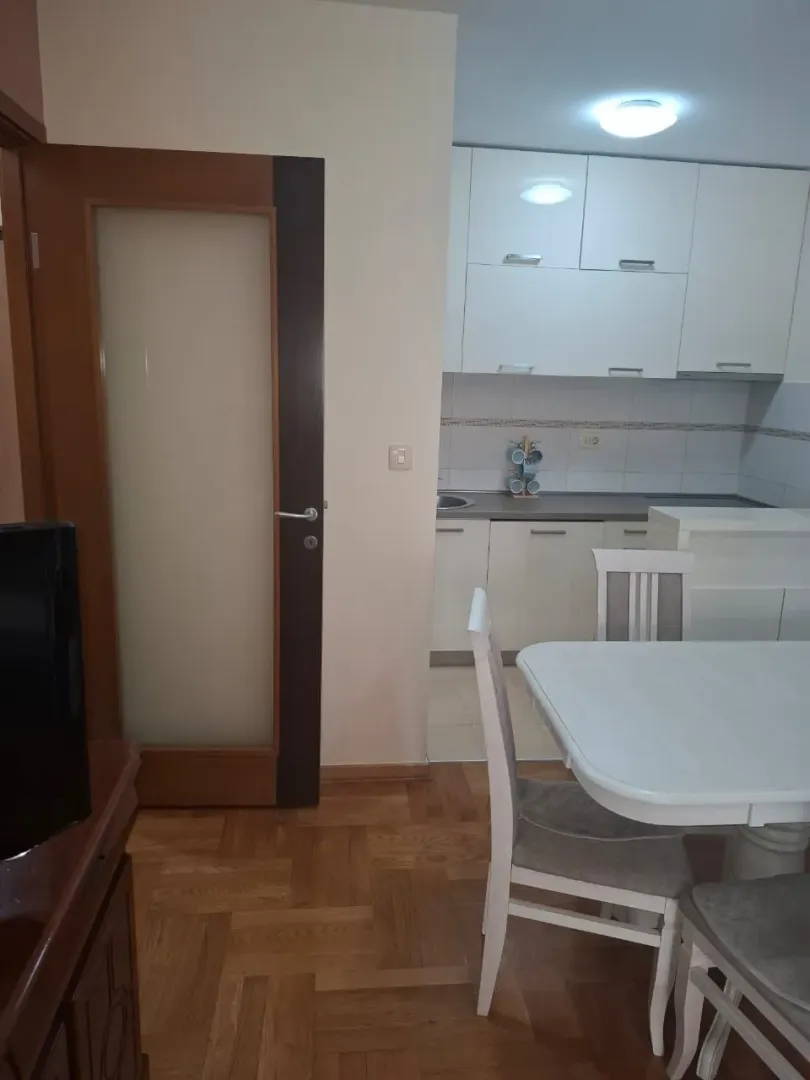 Dining area with a table and chairs and a view of the kitchen.