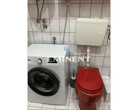 Smaller bathroom with a washing machine and toilet bowl. - image 12