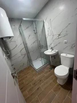 Savremeno opremljeno kupatilo sa tuš kabinom, umivaonikom i toaletom. - image 4