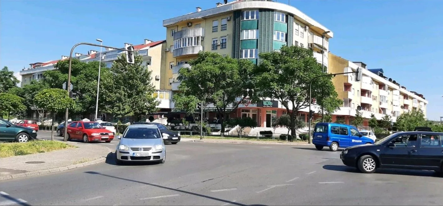 Pogled na stambenu zgradu i raskrsnicu u gradu.