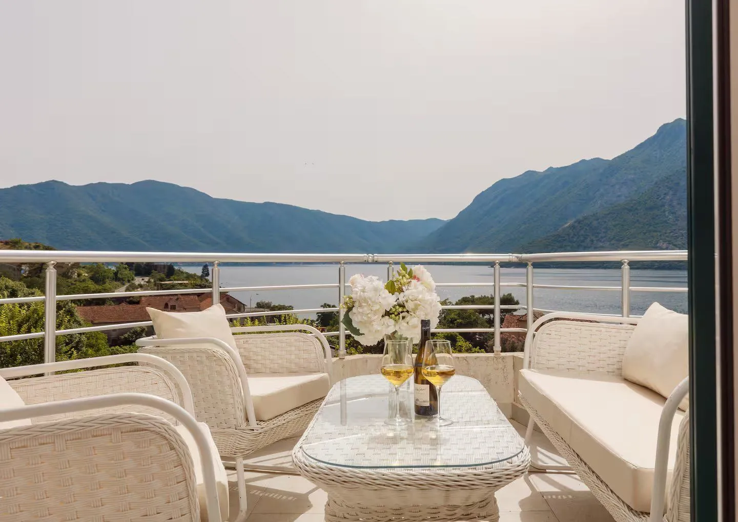 Furnished terrace with seating furniture and a view of the sea and mountains.