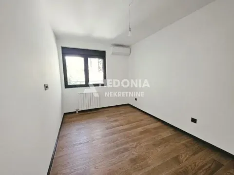 Prazna soba sa belim zidovima i drvenim podom. - image 9
