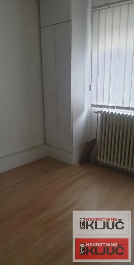 Empty room with a built-in closet and wooden flooring.