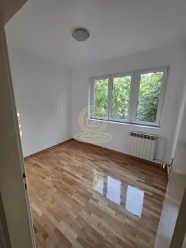 Empty room with parquet flooring and a window overlooking greenery. - image 6
