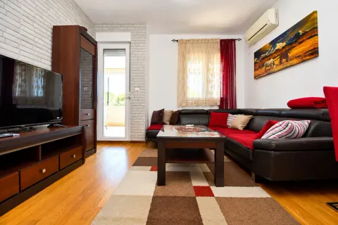 Furnished living room with a sectional sofa, TV, and access to the terrace. - image 2
