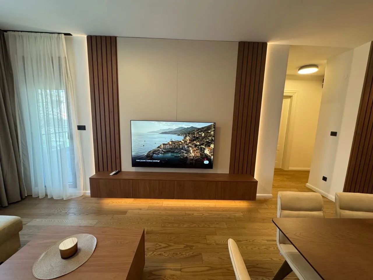 Dnevni boravak sa TV komodom i trpezarijom.