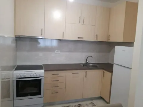 Small kitchen with wooden cabinets, a stove, and a refrigerator. - image 8