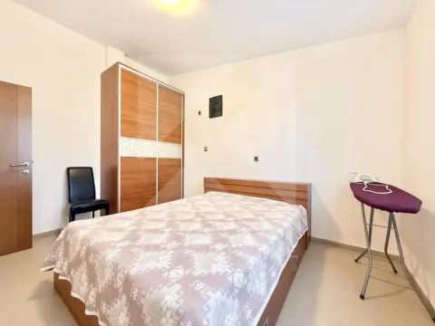 Furnished bedroom with a double bed, wardrobe, and ironing board. - image 4
