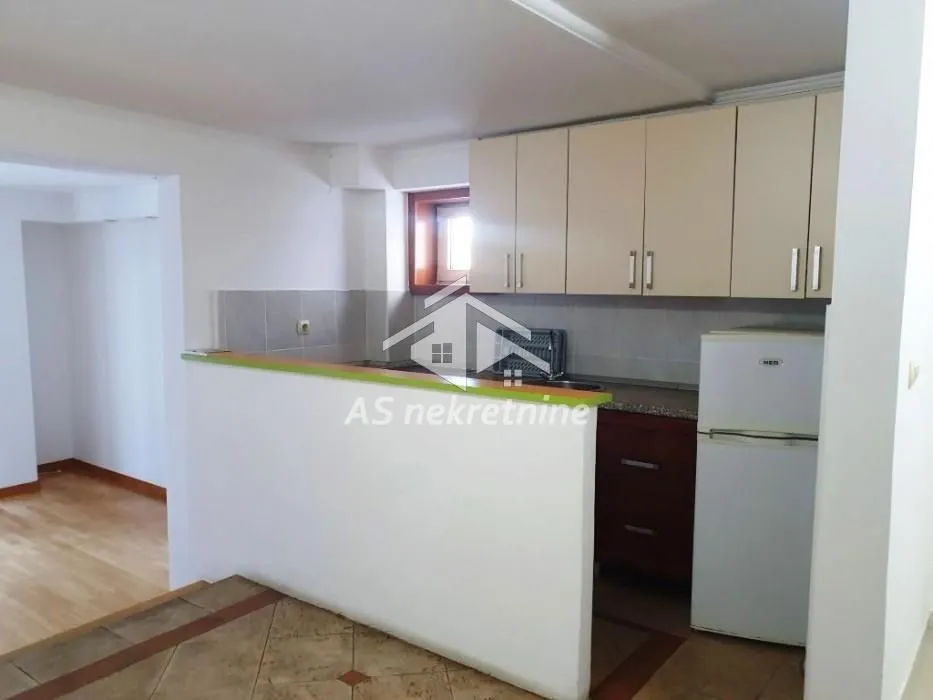 Small kitchen with a breakfast bar and basic units.