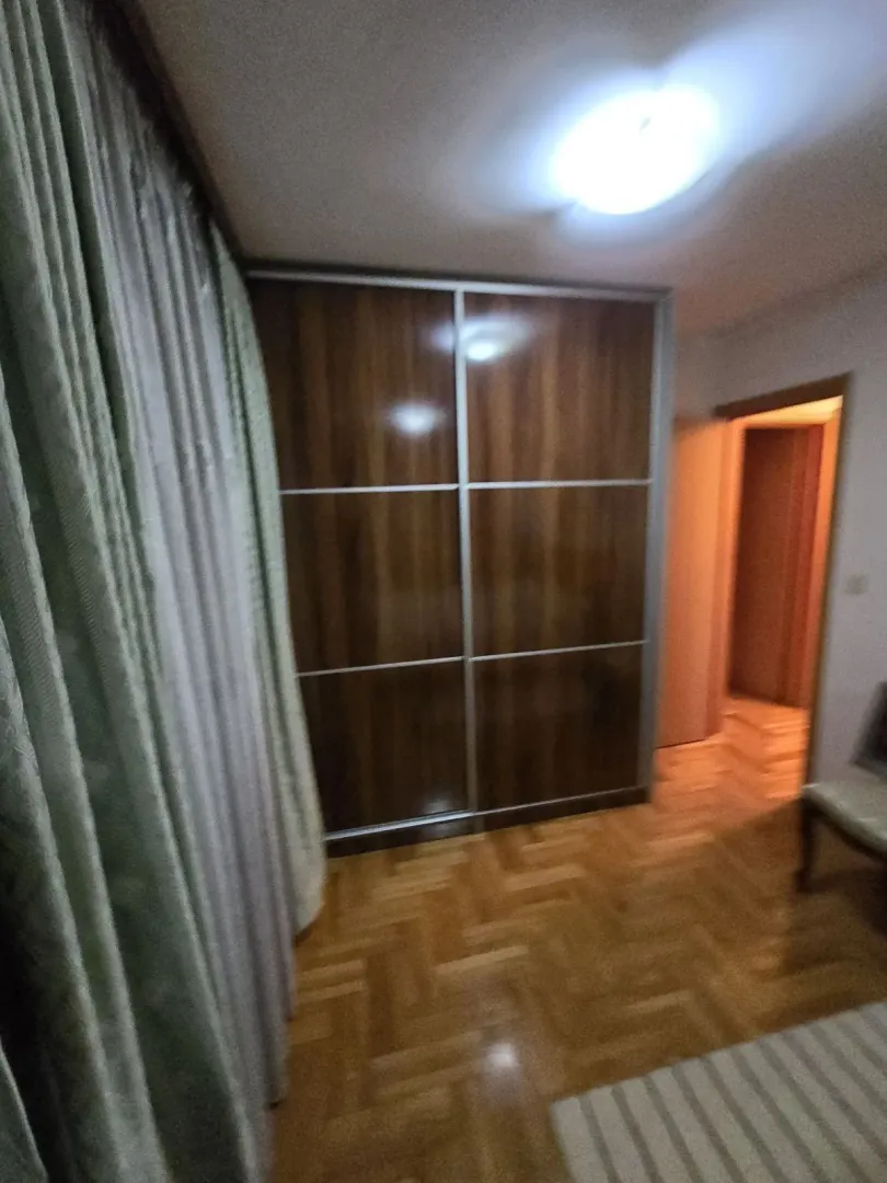 A room featuring a large built-in wardrobe and parquet flooring.