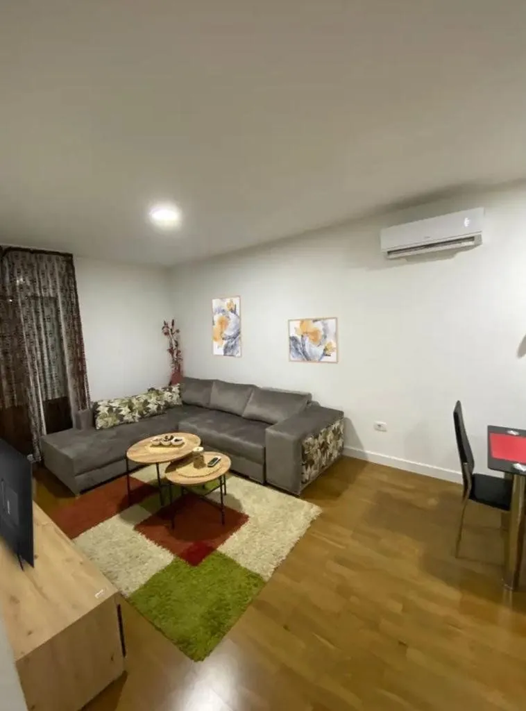 Living room with a sectional sofa, coffee table, and air conditioning unit.