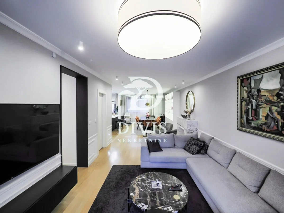 Spacious living room with a sectional sofa, TV, and a view towards the dining area.