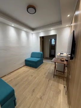 Living room with a blue armchair and a wall-mounted TV. - image 13