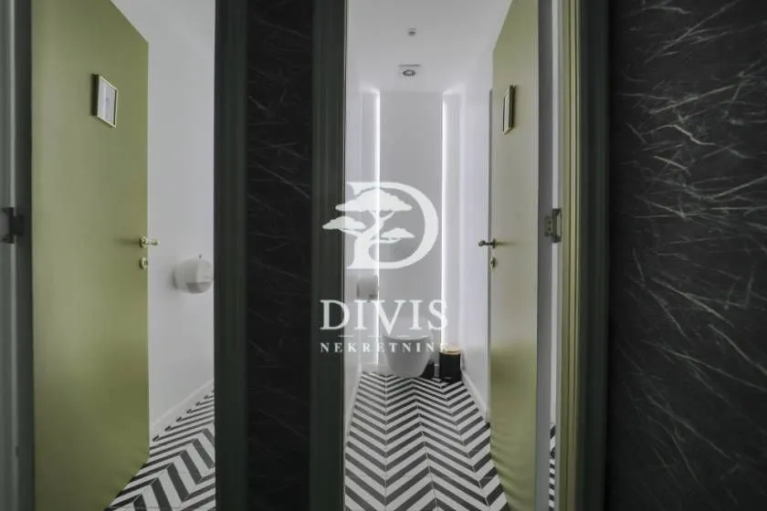 Modern restrooms with black and white patterned flooring and green doors.