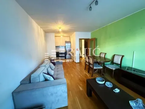 Living room with a sofa, dining area, and a view of the kitchen. - image 10