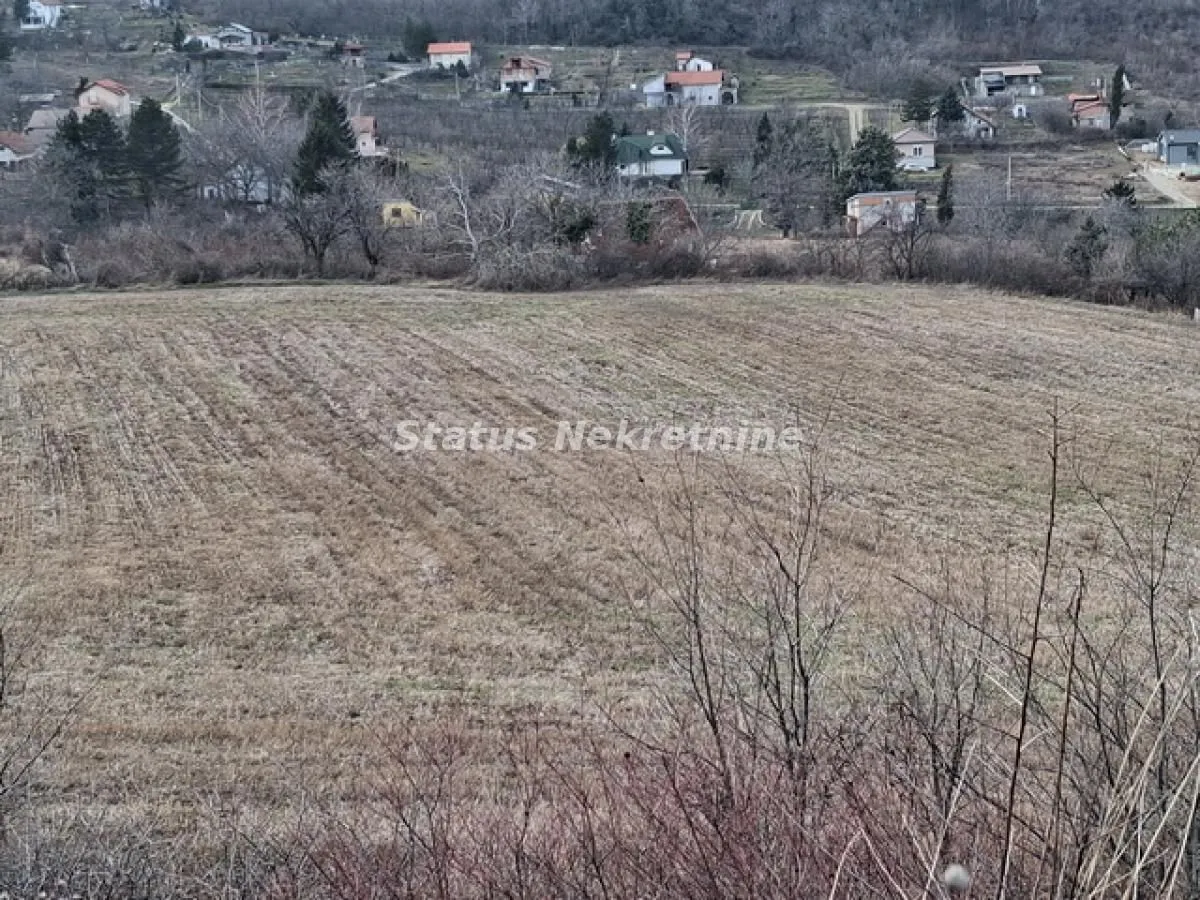 Pogled na prostrano zemljište sa okolnim kućama u pozadini.