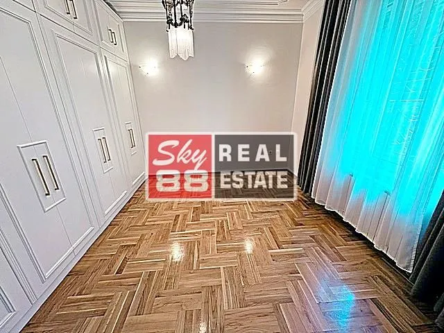 Bedroom with a large built-in wardrobe and wooden parquet flooring.
