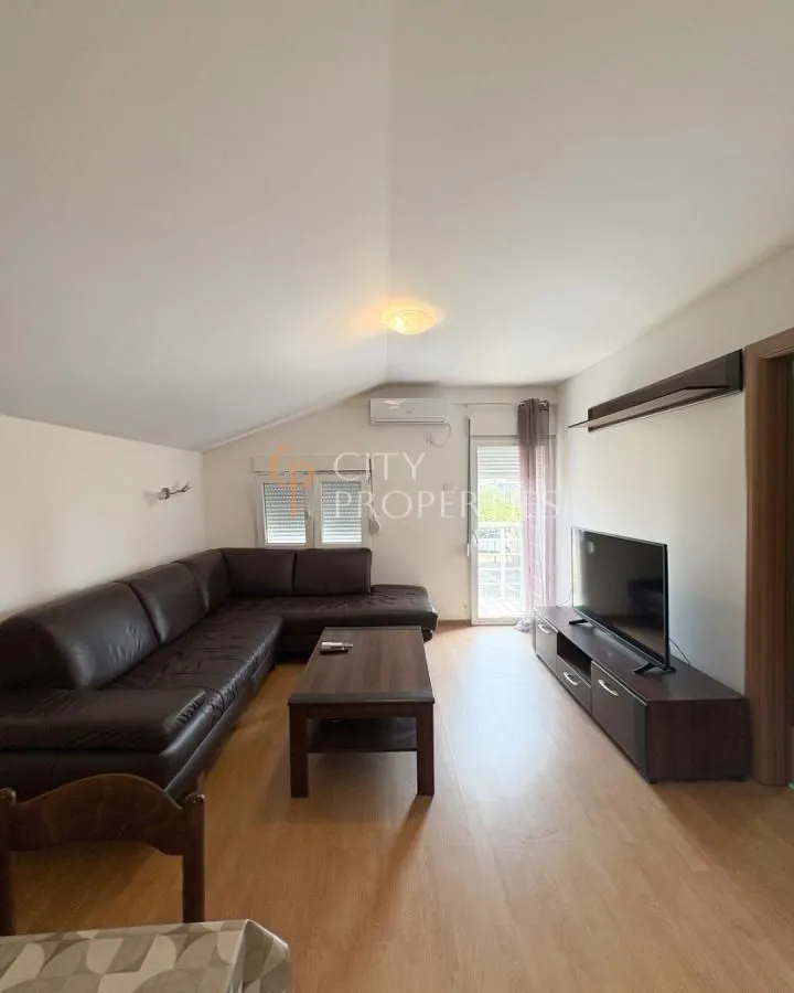 Living room with a sectional sofa, TV, and access to the terrace.