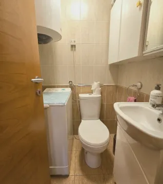 Kompaktno kupatilo sa WC šoljom, umivaonikom, veš mašinom i zidnim ormarićem. - image 8