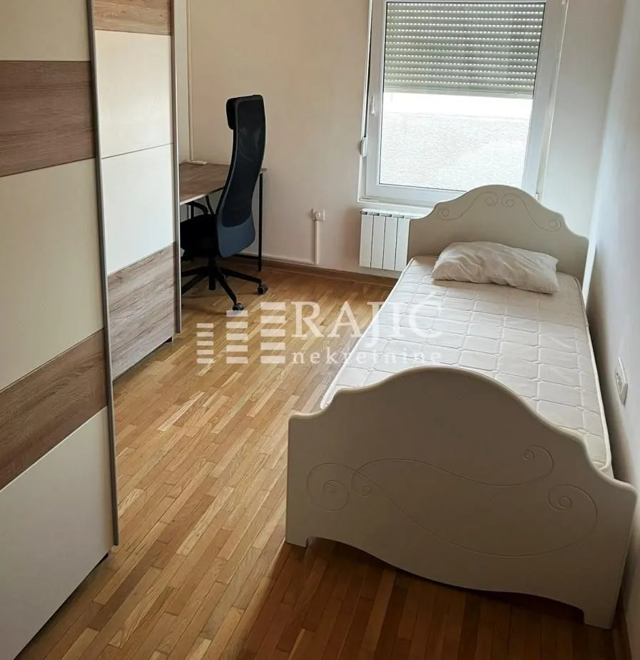 Small bedroom with a bed, desk, and wardrobe.