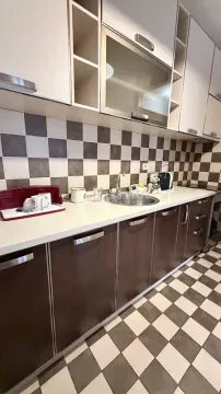 Moderna kuhinja sa bijelim gornjim elementima i tamnim donjim elementima. - image 5
