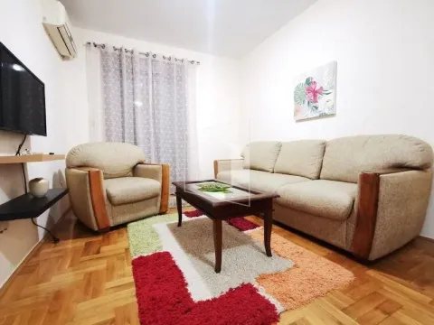 Living room with a seating set, coffee table, and a wall-mounted TV. - image 2