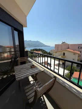 Furnished balcony with a wooden table, chairs and a sea view. - image 3