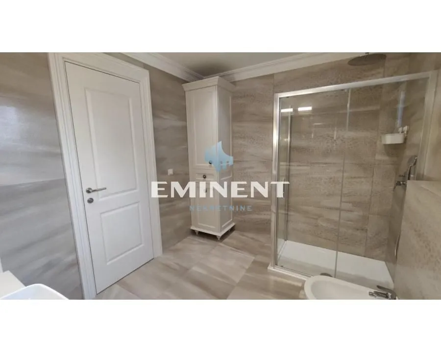 Modern bathroom with a shower cabin and ceramic tiles.