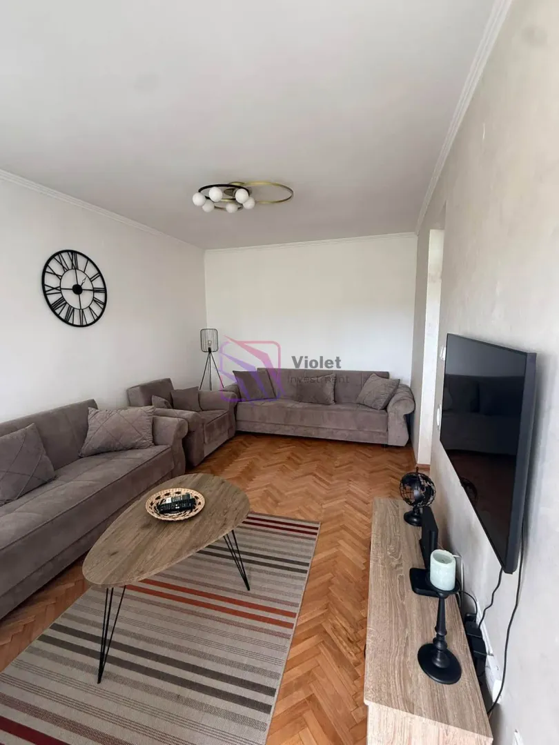 Living room with sofa set, coffee table, and TV.