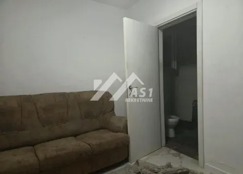 Living room with a sofa and a view of the bathroom through an open door. - image 6