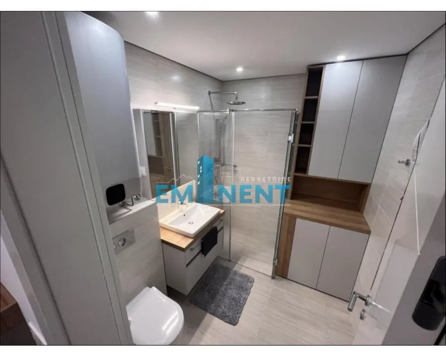 Modern bathroom equipped with a walk-in shower and built-in cabinets.
