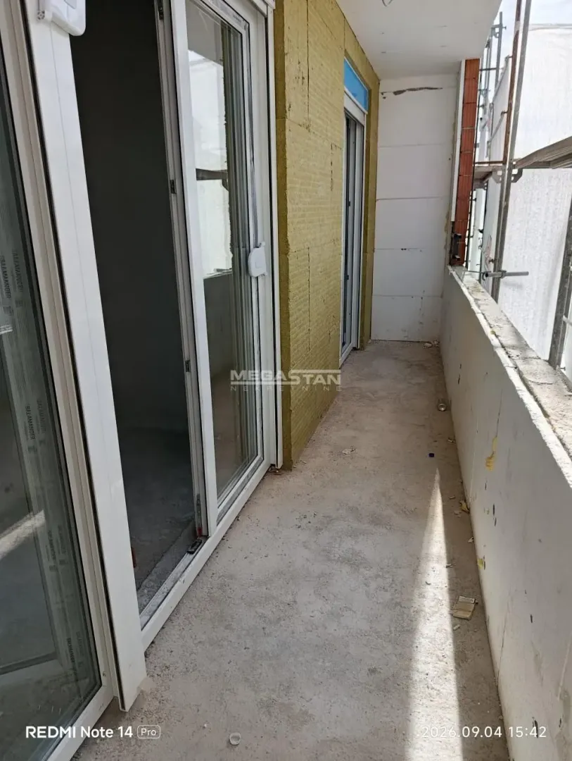 Nezavršen balkon sa kliznim balkonskim vratima na zgradi u izgradnji.