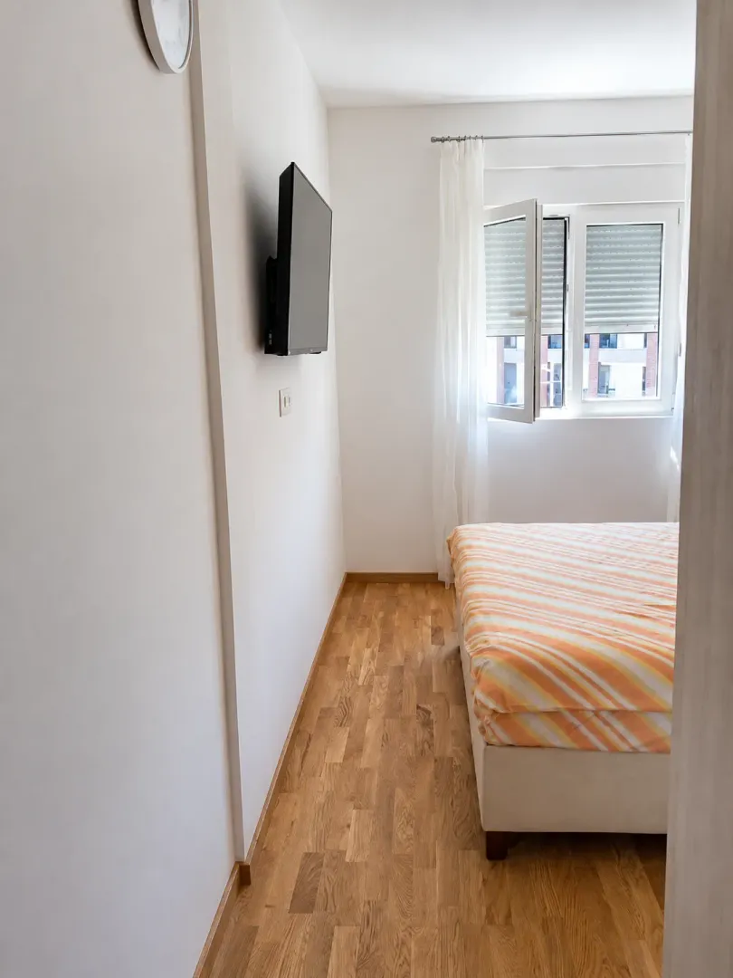 View of the bedroom with a bed and a wall-mounted TV.