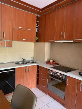 Small kitchen with wooden cabinetry and built-in appliances. - image 3