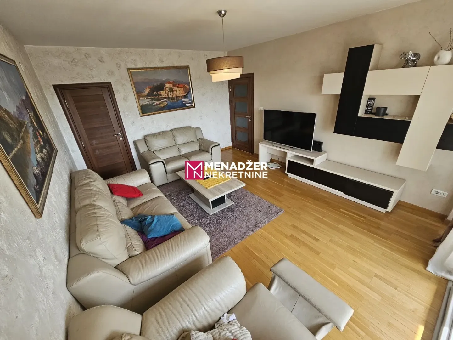 Spacious living room with sofa set and TV.