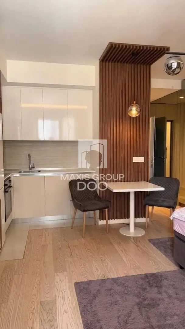 Small kitchen with a dining table and chairs within the apartment.
