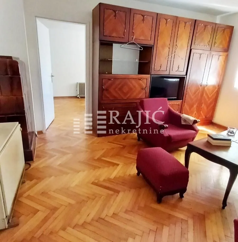 Living room with wooden furniture and parquet flooring.