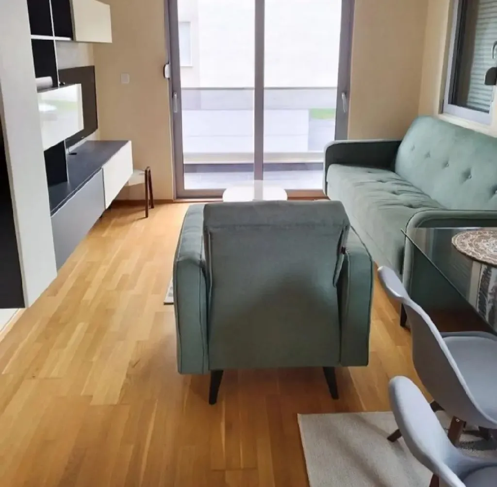 Living room with sofa, TV unit, and access to the terrace.