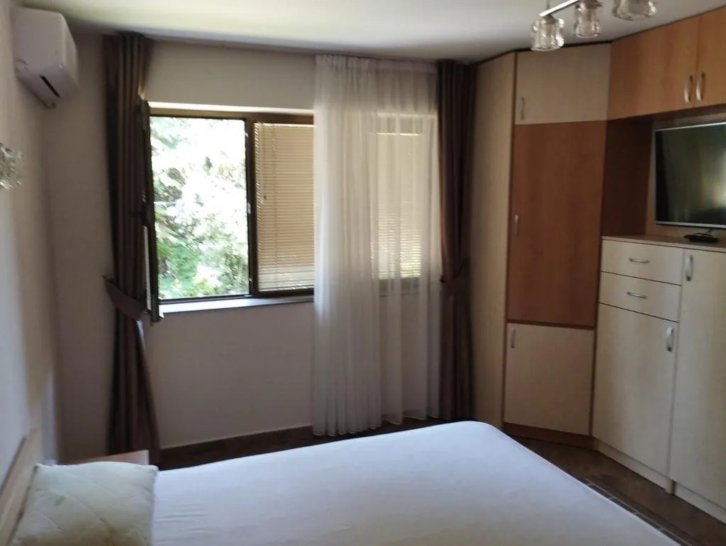 Furnished bedroom with a double bed, a window, and a built-in wardrobe.