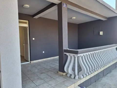Covered terrace with floor tiles and a white balustrade in front of the house entrance. - image 4