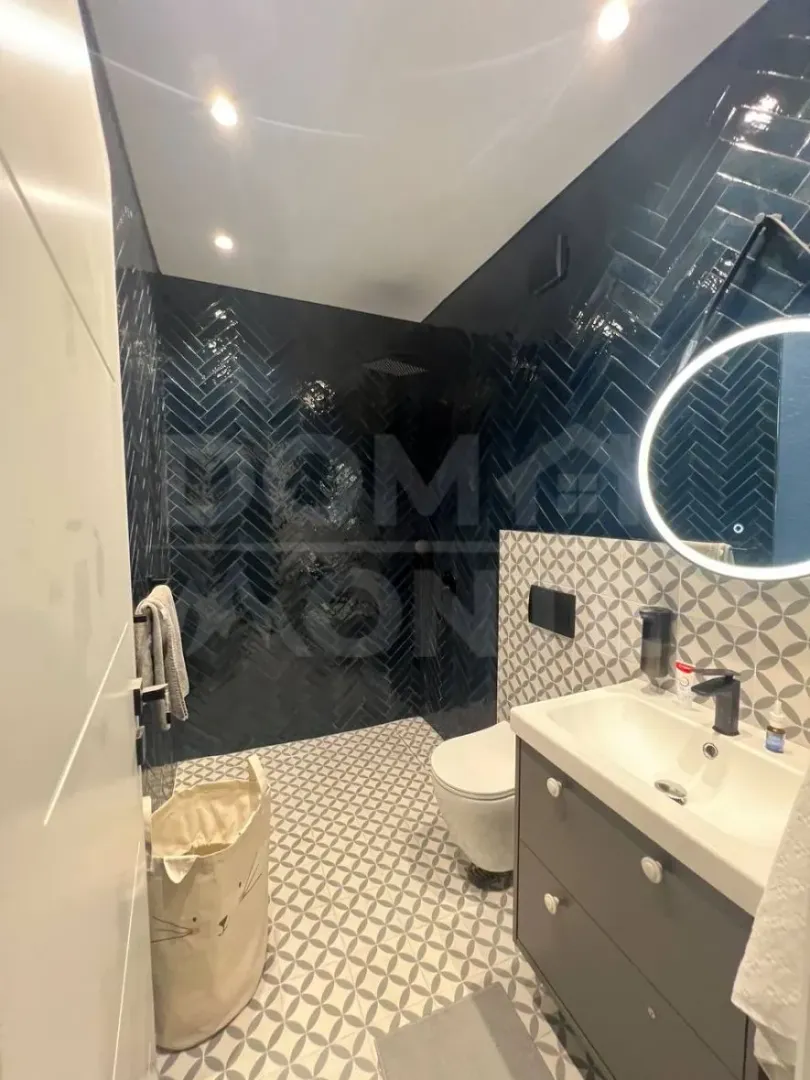 Modernly equipped bathroom with a shower cabin and a sink.
